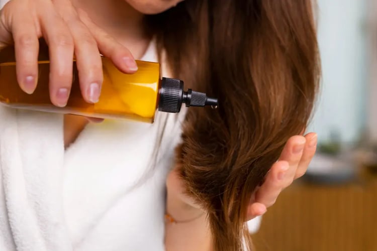Γυναίκα βάζει Argan Oil